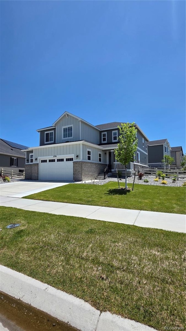 27986 E Frost Pl, Aurora, CO 80016 - view of front of house with board and batten siding, a garage, concrete driveway, and a front yard