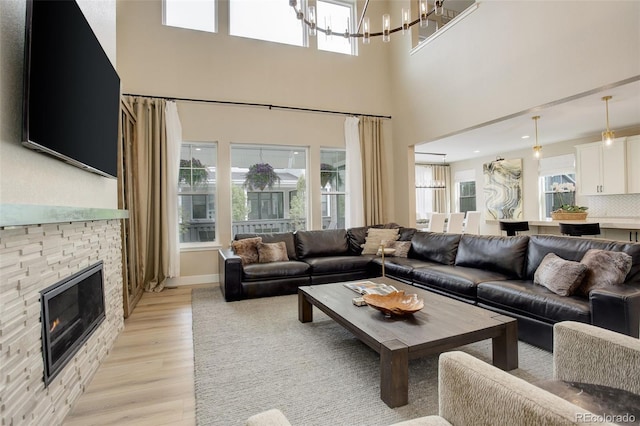 11142 Bright Sky St, Littleton, CO 80125 - living area featuring a chandelier, light wood-style flooring, and a fireplace