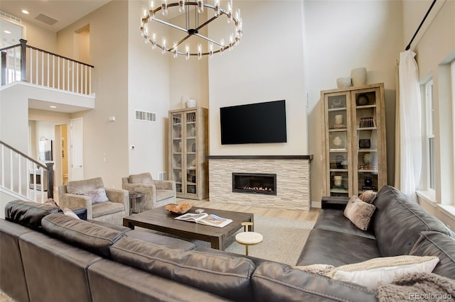 11142 Bright Sky St, Littleton, CO 80125 - living area with a towering ceiling, wood finished floors, a chandelier, stairway, and a tile fireplace
