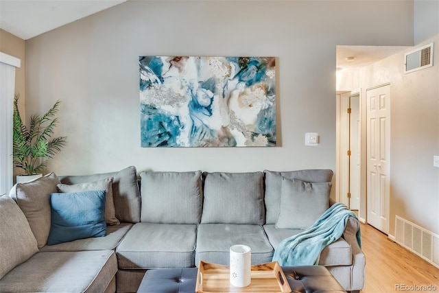 living room featuring vaulted ceiling and light hardwood / wood-style floors