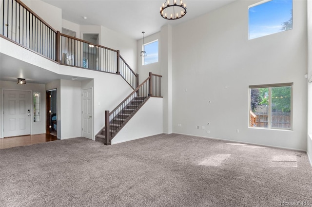 7171 Canyon Way, Frederick, CO 80504 - unfurnished living room with a high ceiling, stairs, carpet, and healthy amount of natural light