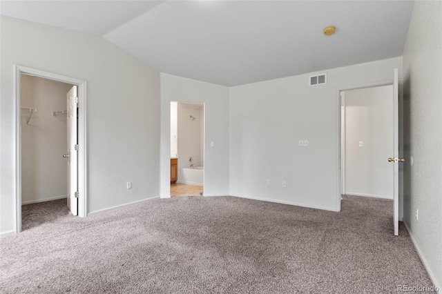 7171 Canyon Way, Frederick, CO 80504 - unfurnished bedroom featuring carpet flooring, a walk in closet, lofted ceiling, ensuite bath, and a closet