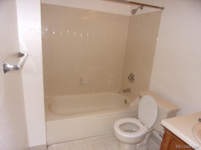 full bathroom featuring tiled shower / bath combo, vanity, and toilet