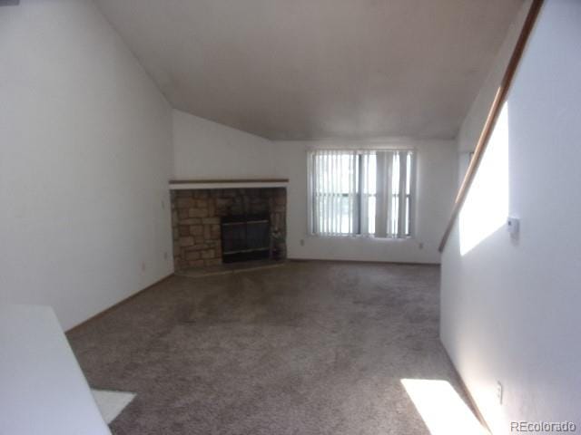 unfurnished living room featuring a fireplace, lofted ceiling, and carpet