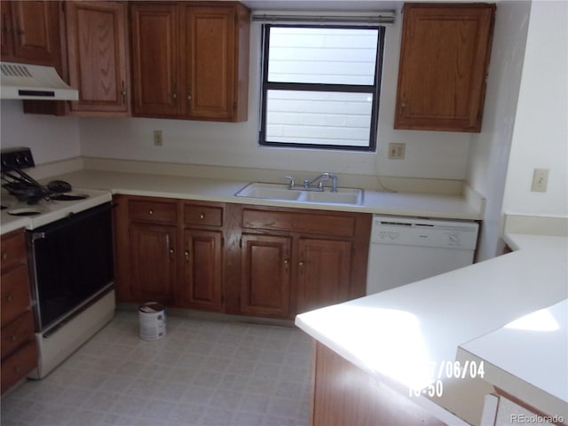 kitchen with white appliances, sink, and range hood