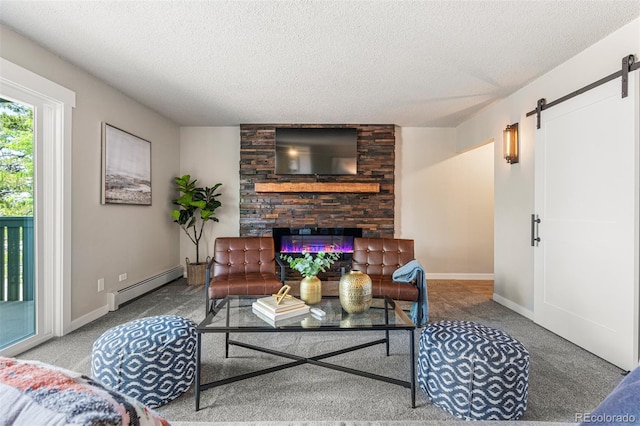 carpeted living room with baseboard heating, a fireplace, a textured ceiling, and a barn door