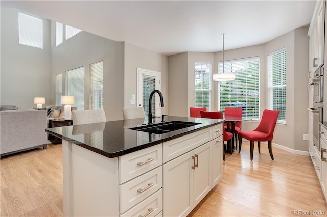 24686 E Florida Ave, Aurora, CO 80018 - kitchen with a sink, light wood finished floors, and white cabinetry