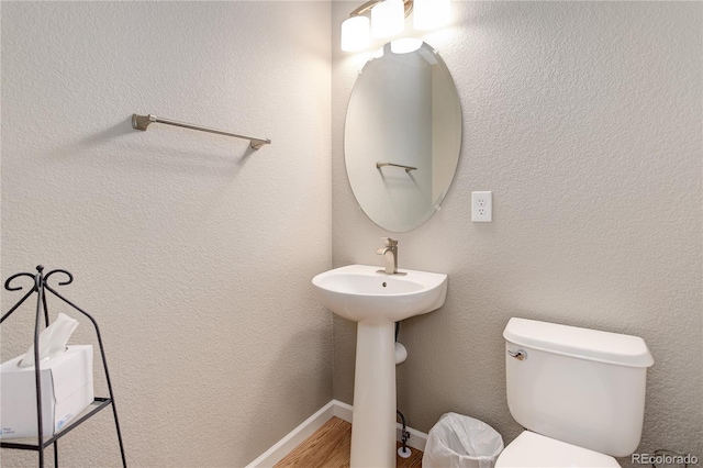 24686 E Florida Ave, Aurora, CO 80018 - half bathroom featuring toilet, wood finished floors, and a sink