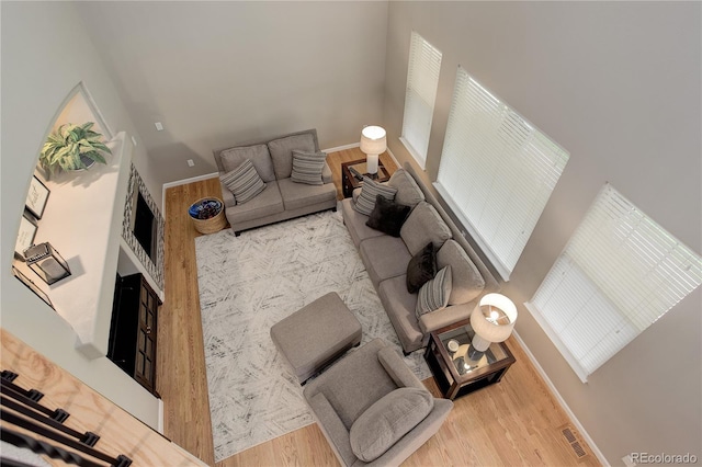 24686 E Florida Ave, Aurora, CO 80018 - living room featuring wood finished floors, a towering ceiling, and baseboards