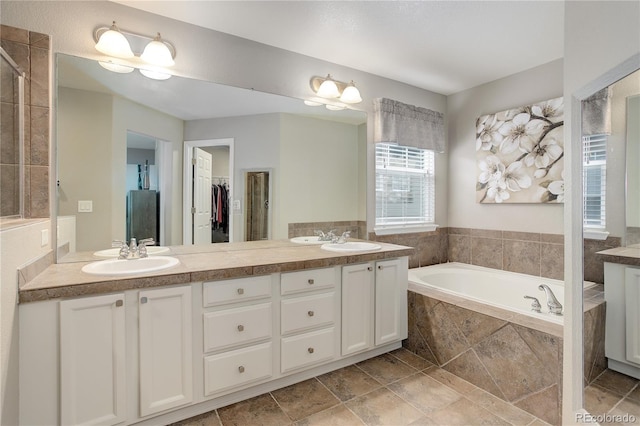 24686 E Florida Ave, Aurora, CO 80018 - full bathroom featuring double vanity, a garden tub, and a walk in closet