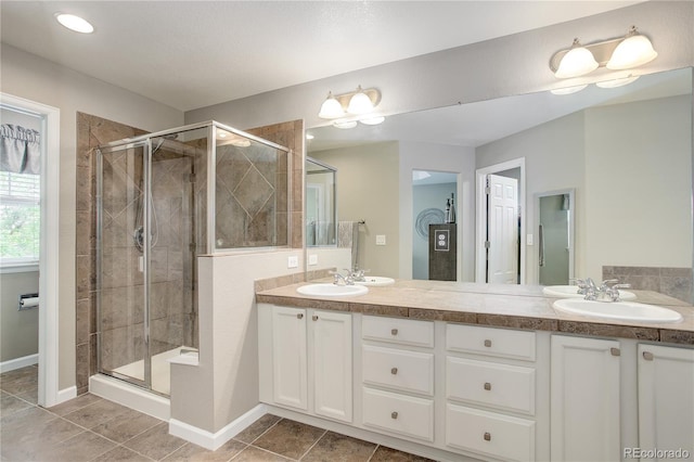 24686 E Florida Ave, Aurora, CO 80018 - bathroom featuring double vanity, a shower stall, tile patterned flooring, and baseboards