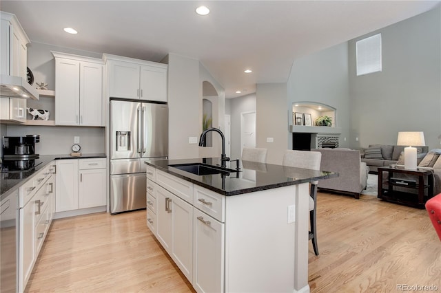 24686 E Florida Ave, Aurora, CO 80018 - kitchen with stainless steel refrigerator with ice dispenser, a sink, light wood-type flooring, arched walkways, and open shelves