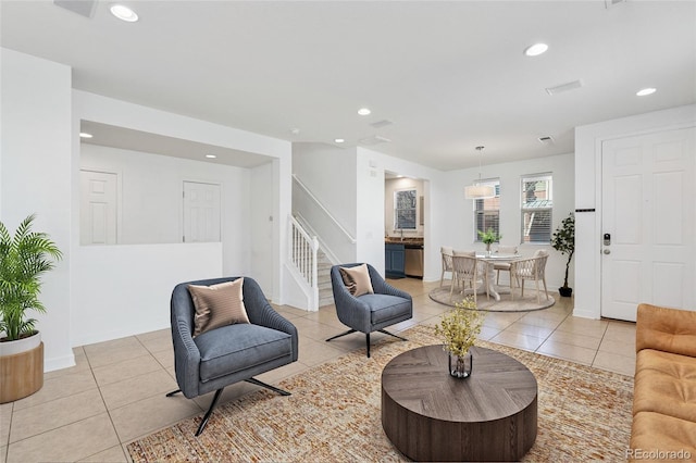 living area with light tile patterned floors, stairs, and recessed lighting