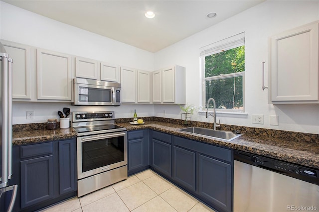 kitchen with blue cabinetry, light tile patterned floors, recessed lighting, appliances with stainless steel finishes, and a sink