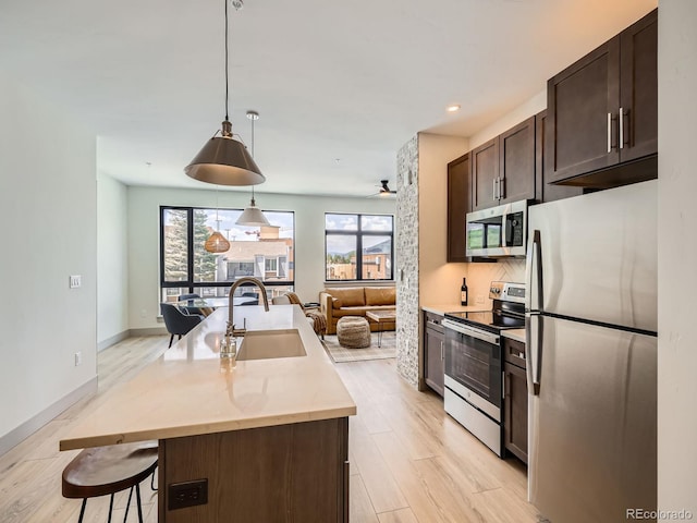 75 W 4th St Unit 205W, Silverthorne, CO 80498 - kitchen with appliances with stainless steel finishes, dark brown cabinets, plenty of natural light, light wood finished floors, and recessed lighting