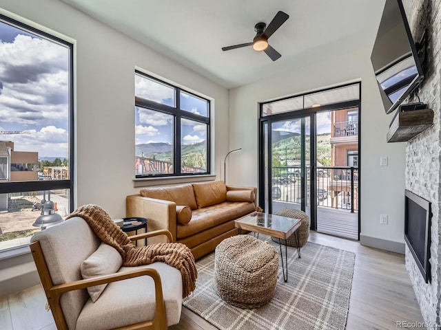 75 W 4th St Unit 205W, Silverthorne, CO 80498 - living area with ceiling fan, a stone fireplace, and light wood-style floors