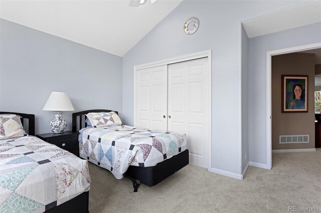 carpeted bedroom with a closet, vaulted ceiling, and baseboards
