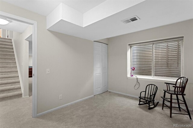 living area with carpet floors, stairs, and baseboards