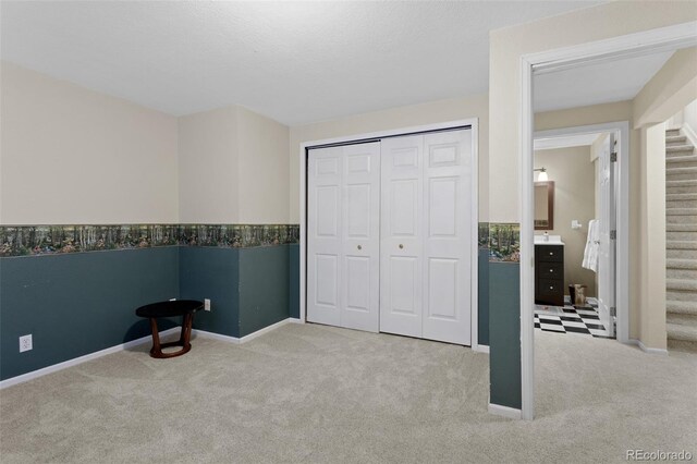 unfurnished bedroom with carpet, baseboards, and a closet