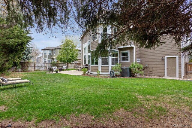 view of yard featuring a sunroom, a patio, and central air condition unit