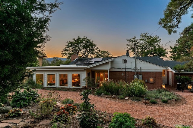 back house at dusk featuring solar panels