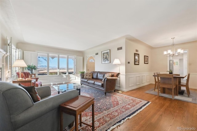 living room with a chandelier and light hardwood / wood-style flooring