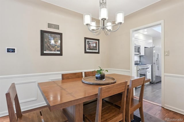 dining room featuring hardwood / wood-style flooring and an inviting chandelier