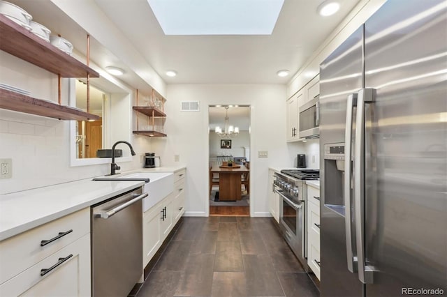 kitchen featuring a chandelier, sink, white cabinets, decorative backsplash, and stainless steel appliances