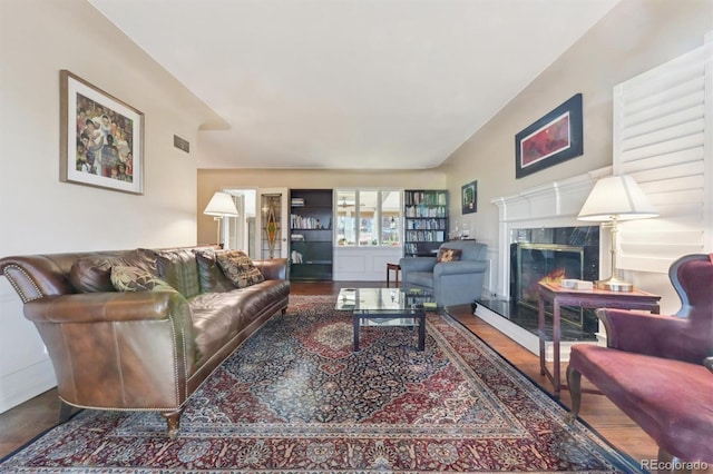 living room featuring wood-type flooring and a high end fireplace