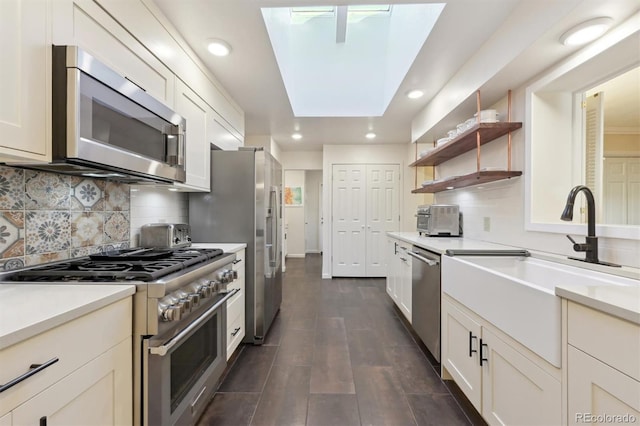 kitchen with appliances with stainless steel finishes, dark wood-type flooring, white cabinetry, sink, and backsplash