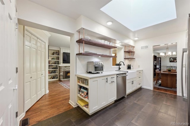 kitchen with white cabinets, an inviting chandelier, sink, dark hardwood / wood-style floors, and stainless steel dishwasher