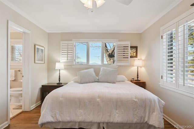 bedroom with ceiling fan, wood-type flooring, multiple windows, and ensuite bath