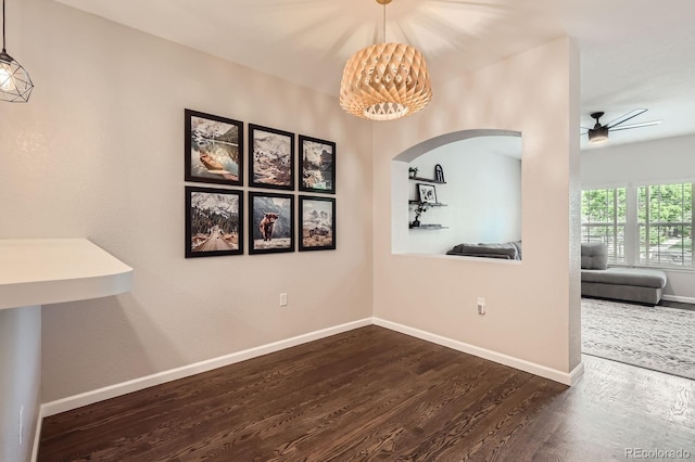 1539 Bennet Mountain Rd, Castle Rock, CO 80109 - unfurnished dining area featuring arched walkways, dark wood finished floors, a chandelier, baseboards, and ceiling fan