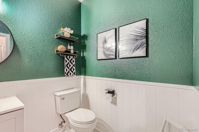 1539 Bennet Mountain Rd, Castle Rock, CO 80109 - bathroom featuring toilet, wainscoting, vanity, and a textured wall