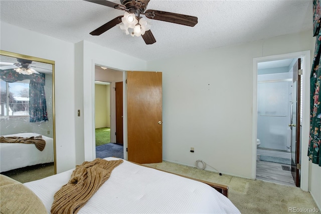 carpeted bedroom with ceiling fan, a closet, connected bathroom, and a textured ceiling