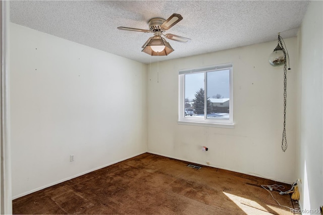 carpeted spare room with ceiling fan and a textured ceiling