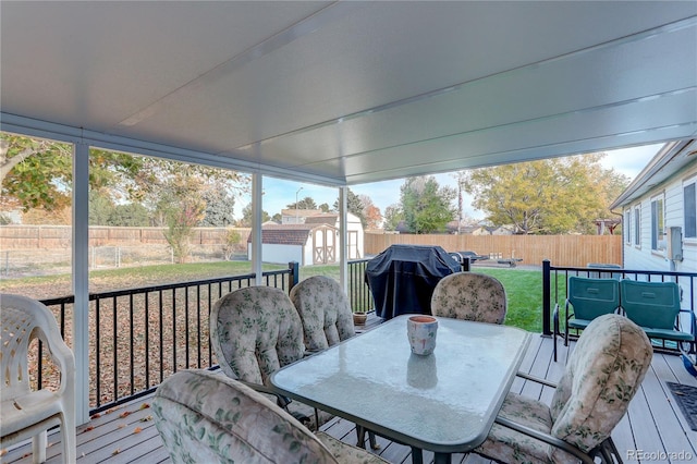 wooden deck with a yard, grilling area, and a shed