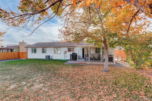 back of house featuring central AC unit and a lawn