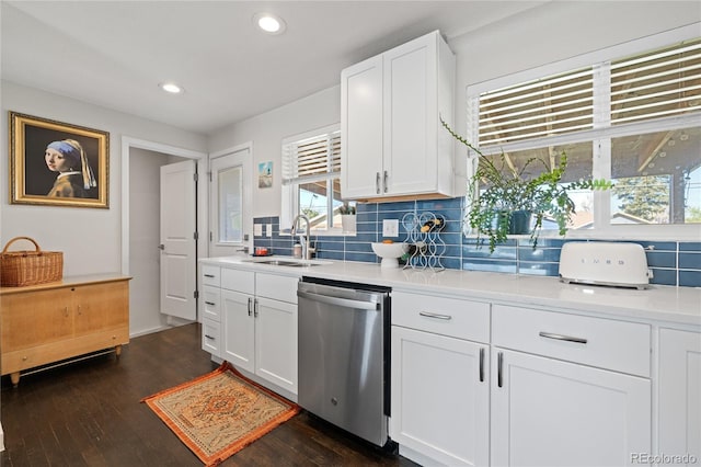 kitchen featuring dishwasher, a sink, tasteful backsplash, dark wood finished floors, and light countertops