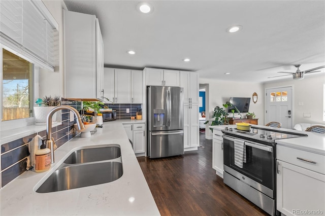 kitchen with stainless steel appliances, a sink, tasteful backsplash, recessed lighting, and dark wood-style flooring