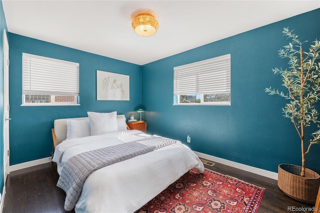 bedroom with wood finished floors and baseboards