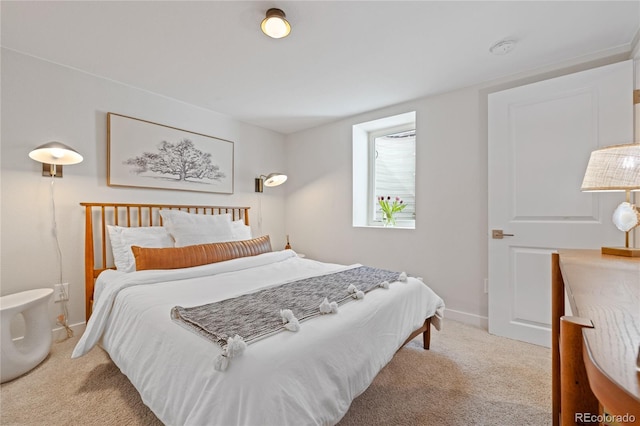 bedroom with light carpet and baseboards