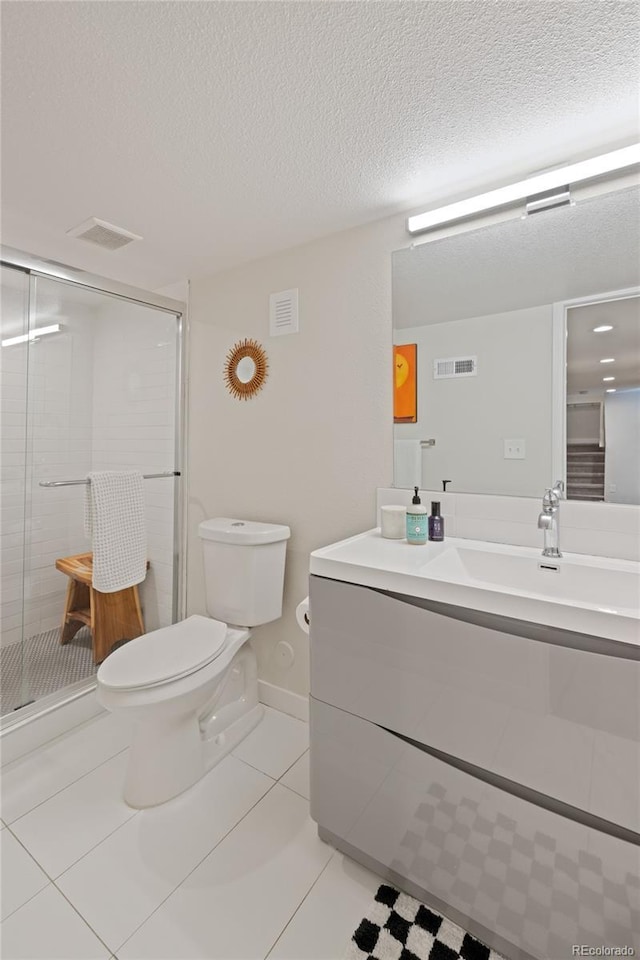 full bathroom featuring toilet, vanity, a stall shower, tile patterned flooring, and a textured ceiling