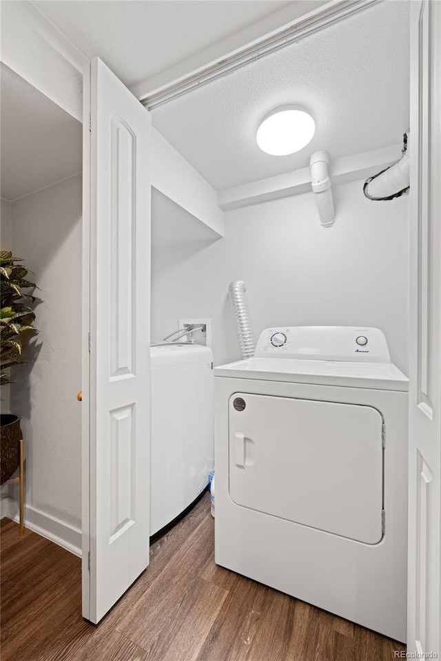 washroom with separate washer and dryer, wood finished floors, and a textured ceiling