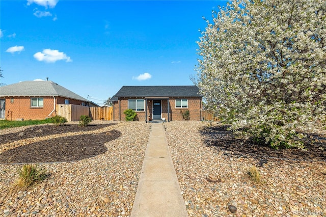 view of front of home featuring brick siding and fence