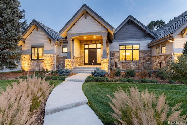 craftsman house with covered porch and a front yard