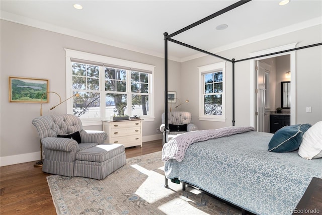 bedroom featuring ensuite bath, wood-type flooring, and ornamental molding