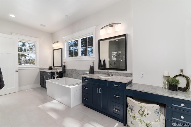 bathroom featuring a tub, tile patterned flooring, and vanity