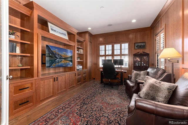 interior space featuring built in features, crown molding, and wooden walls