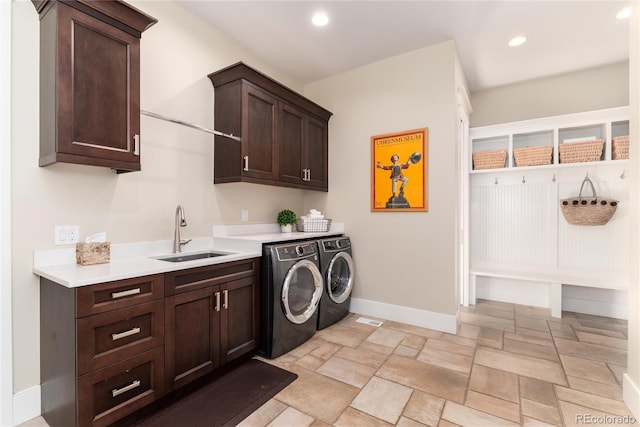 laundry area with cabinets, washing machine and dryer, and sink